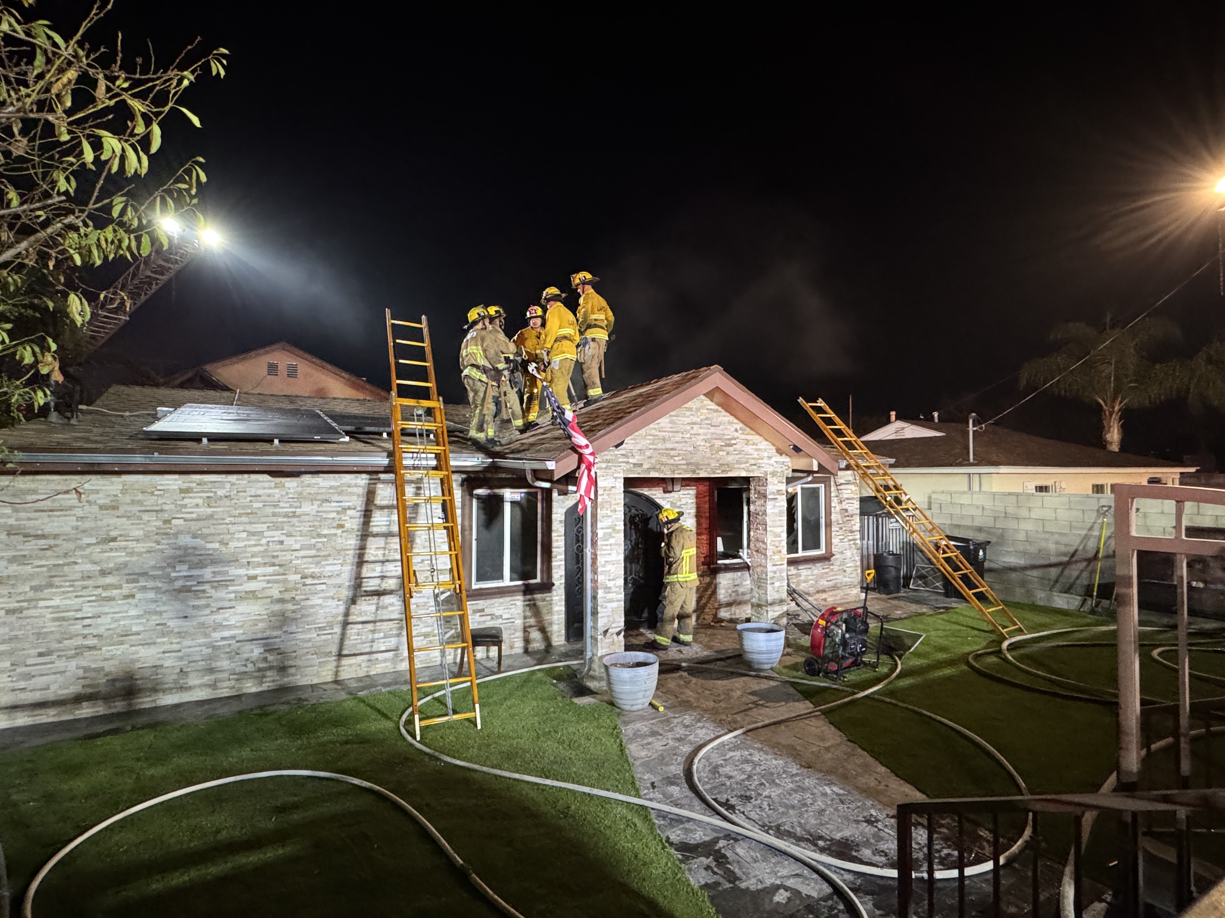 Firefighters on the roof of home after extinguishing the fire