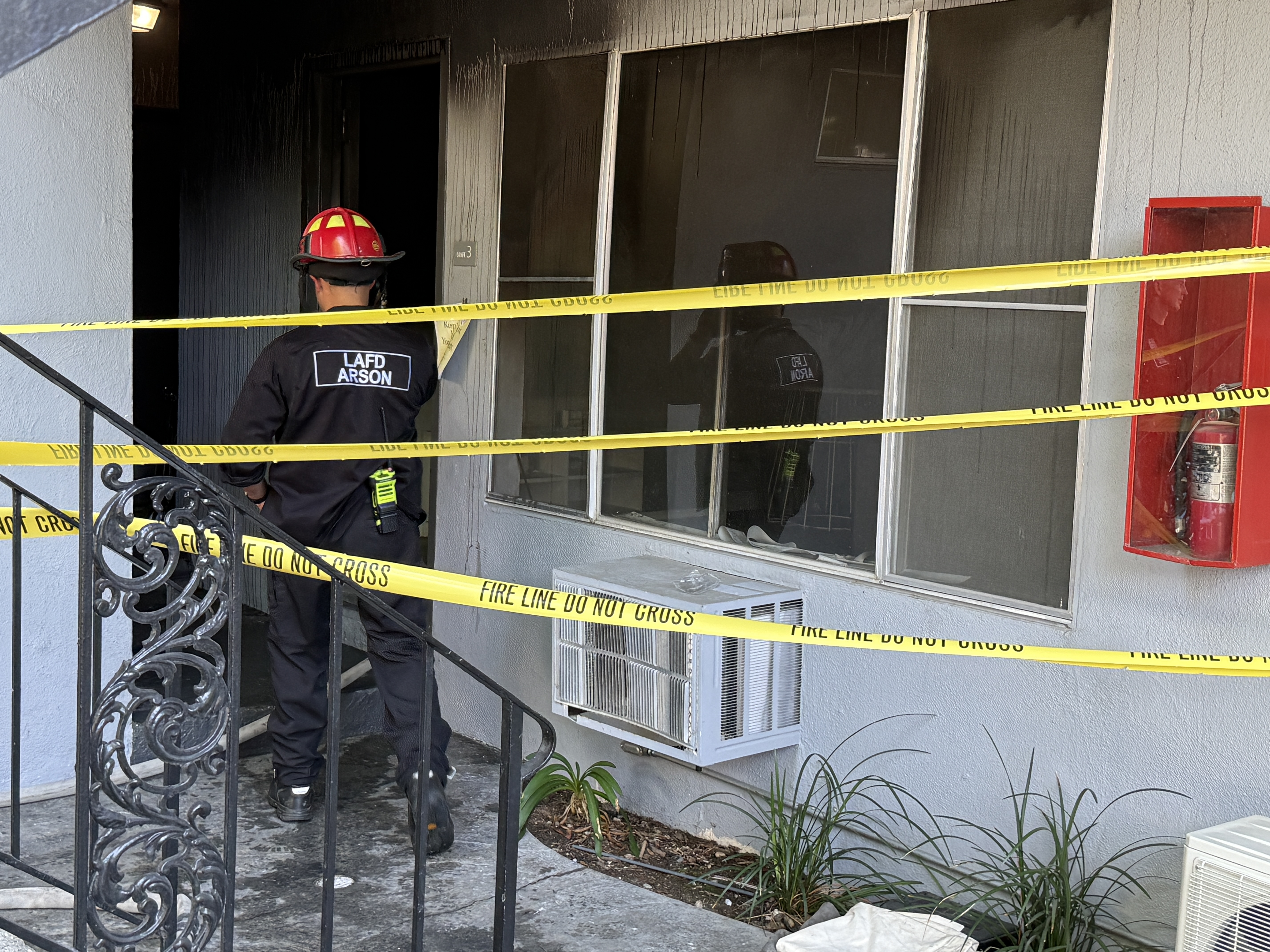 Arson investigator in front of the unit with visible fire damage